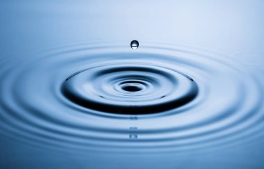 Mavi su damlası düşüyor, makro sıçrama. Doğal arkaplan.