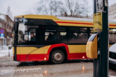 Arka planda araba olan bir şehir caddesinde bir otobüs.