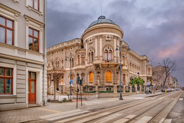 Tren yolu ve binası olan bir cadde.