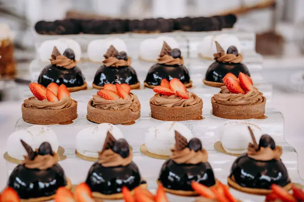 Üstünde çilek olan çikolatalı kek gösterisi.