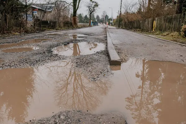 Tahta çitli yolda bir su birikintisi.