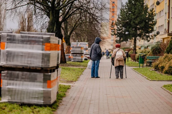 Kaldırımda yürüyen bir çift insan.