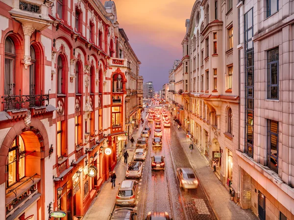 Üzerinde arabalar ve otobüsler olan bir şehir caddesi.