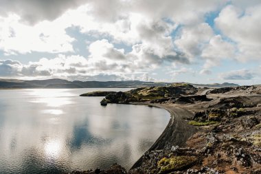 Arka planda dağ olan bir su kütlesi.