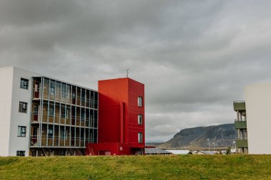 Arka planda beyaz bir bina olan kırmızı bir bina.