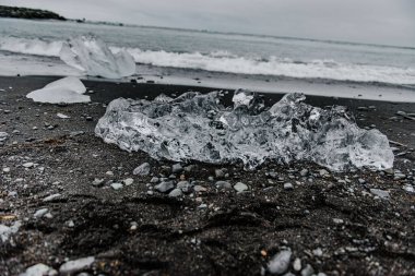 Kumda buz parçaları olan bir kumsal.