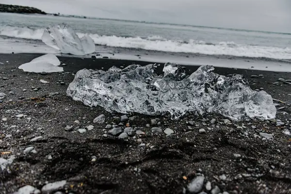 Kumda buz parçaları olan bir kumsal.