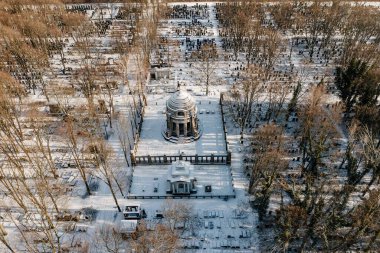 Karlı bir arazinin ortasında bir bina.