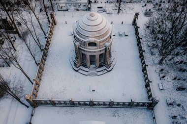 Karlı bir parkın ortasında kubbeli bir bina.