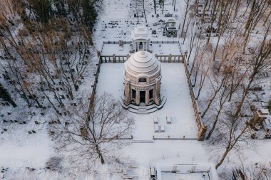 Karlı bir parkın ortasında kubbeli bir bina.