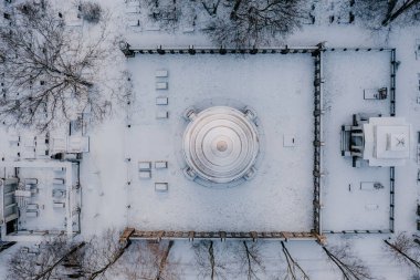 Yuvarlak binalı, karla kaplı bir şehir.