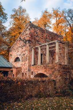Önünde sütunları ve saati olan tuğla bir bina.
