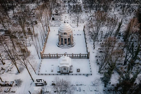 Karlı bir parkın ortasında kubbeli büyük bir bina.