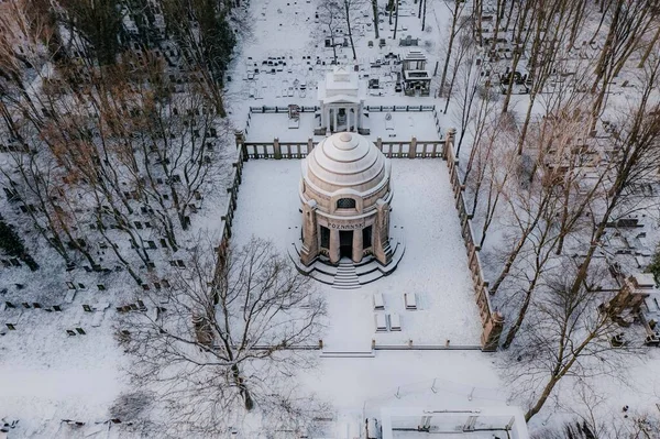 Karlı bir parkın ortasında kubbeli bir bina.