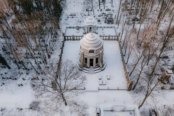 Karlı bir parkın ortasında kubbeli bir bina.