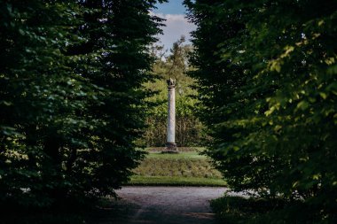 Ağaçlarla ve patikalarla çevrili bir anıt.