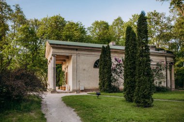 Yeşil çatılı ve yolu olan küçük bir bina.