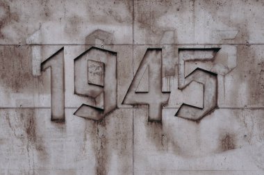 Üzerinde numara ve yangın musluğu olan bir duvar.