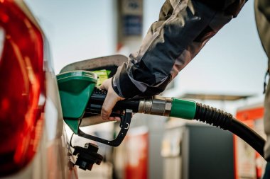 Bir arabayı benzinle dolduran kişi.