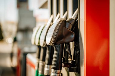 Benzin hortumu ve kırmızı duvarı olan bir benzin pompası.