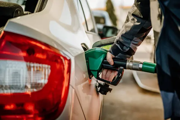 Bir arabayı benzinle dolduran kişi.