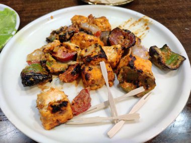 Paneer Tikka, yeşil acı biber ve domates sosuyla servis edilen Hint aperatifi., 