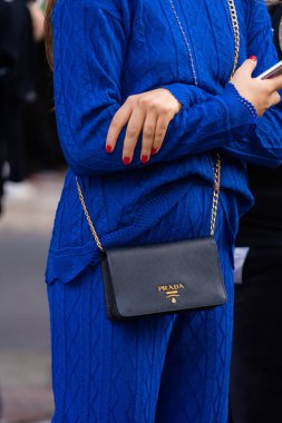 Milan, İtalya - 21 Eylül 2022: Sokak tarzı kıyafet yakın çekim detayları, şık bir kadın elektrikli mavi örgü takım elbise giyiyor, Prada 'dan siyah deri, lüks bir çanta. Bloglama ve sokak tarzı kavramı