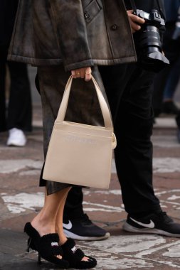 Milan, İtalya - 21 Eylül 2022: Kadın koyu kahverengi ve siyah deri ceket, deri düğmeli gilet, siyah ve parlak deri midi etek, Balenciaga 'dan tüylü sandaletler, Chanel marka el çantası