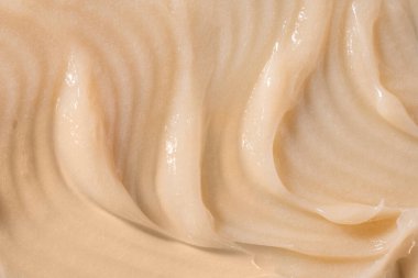 Vücut bakım kremi, retinol serumu, şampuan dalgalı doku. Saç kremi arka planı. Sarı kozmetik losyon nemlendirici numunesi yakın çekim. Cilt maskesi lekesi, kremalı temizleyici ürün örneği