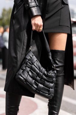 Milan, İtalya - 21 Eylül 2022: Mango örülmüş omuz çantası takan kadın siyah, sokak tarzı kıyafet ayrıntıları.