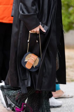 Milan, İtalya - 21 Eylül 2022: Borbonese 'den gelen kahverengi ve mavi süet çanta giyen kadın, sokak tarzı kıyafet ayrıntıları.