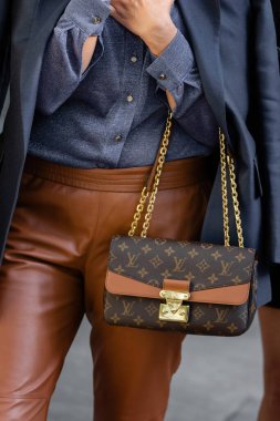 Milan, İtalya - 22 Eylül 2022: Kadın, Louis Vuitton 'dan zincirli çapraz vücut çantası Marceau tuval monogram altın takıyor.