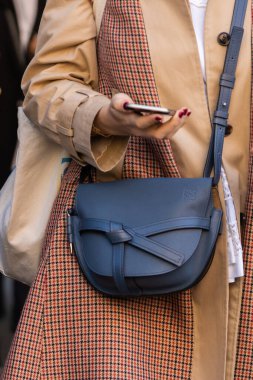 Milan, İtalya - 23 Eylül 2022: Loewe 'den mavi kapılı çift deri çanta giyen kadın, sokak tarzı kıyafet ayrıntıları.