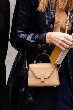 Paris, Fransa - Ekim, 3, 2022: Kadınlar Valextra 'nın mini çantalarından giyiyorlar, sokak tarzı detaylar..