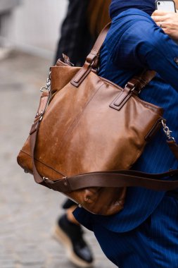 Paris, Fransa - Ekim, 3, 2022: Adam kahverengi deri çanta giyiyor, sokak tarzı detaylar.