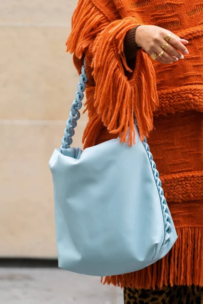 フランス 2022年10月3日 女性はオレンジ色のニットポンチョとブルーのファラベラのパッド入りショルダーバッグを身に着けていますステラマッカートニー ストリートスタイルの詳細 — ストック写真