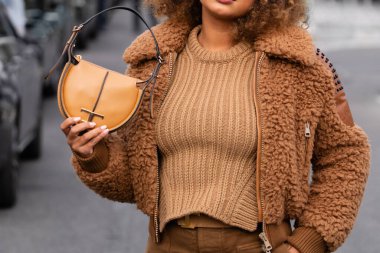 Milan, İtalya - 23 Eylül: kahverengi kürk ceket giyen kadın nüfuzlu ve Tods veya Tods 'dan altın renkli bir logo taşıyan kahverengi omuz çantalı. Moda blogcusu kıyafet detayları, sokak tarzı.