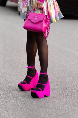 Milan, İtalya - 23 Eylül: Versace La Medusa marka pembe neon çanta giyen kadın etkili, Versace 'den saten topuklu sandaletler. Moda blogcusu kıyafet detayları, sokak tarzı.