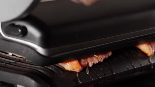 鮭の魚を電気グリルでローズマリーで焼き カバーを閉じます 食事の準備 健康的な食事のコンセプト クローズアップビュー — ストック動画
