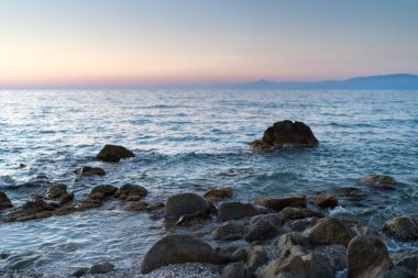 Beautiful view of orange sunset seascape with rocks in Italy. Tropical colourful sunrise landscape. Nature landscape. Tropical island coast