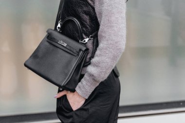 Milan, İtalya - 24 Şubat 2022: Kadın deri Kelly Hermes siyah çanta giyiyor, sokak tarzı detaylar.