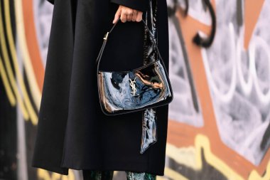 Milan, İtalya - 13 Ocak 2023: Kadın siyah deri çanta giyiyor Yves Saint Laurent, sokak tarzı detaylar.
