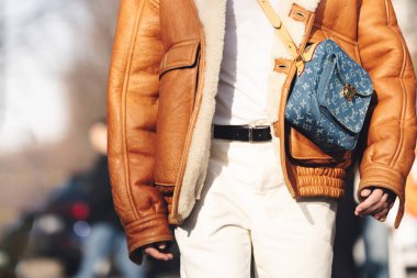 Milan, İtalya - 13 Ocak 2023: Adam mavi monogram kot giyiyor Louis Vuitton Bum Bag altın donanım, sokak tarzı detaylar