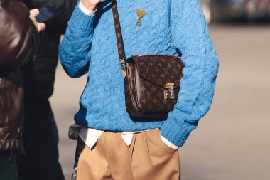 Milan, İtalya - 13 Ocak 2023: Adam pochette metis Louis Vuitton çanta giyiyor, sokak tarzı detaylar.