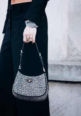 Milan, İtalya - 13 Ocak 2023: Kadın düşesten yapılmış Prada Cleo çanta giyiyor ve aydınlık kristallerle süslenmiş, sokak tarzı detaylarla süslenmiş