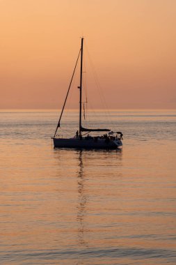 Tropea, İtalya - 17 Temmuz 2022: Yazın gün batımında yelkenli tekneli güzel deniz manzarası. Seyahat, hobi konsepti