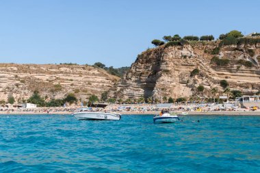 Tropea, İtalya - 17 Temmuz 2022 Yazın güneşli bir günde yelkenli tekneli güzel bir deniz manzarası. Seyahat, hobi konsepti.