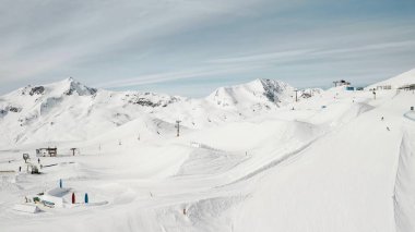 Kayak merkezinde snowboard yapan insanlar. Kayakçılar, snowboardcular karlı dağ yamacına çıkıyorlar. Açık hava kış sporu ve muhteşem panoramik manzara.