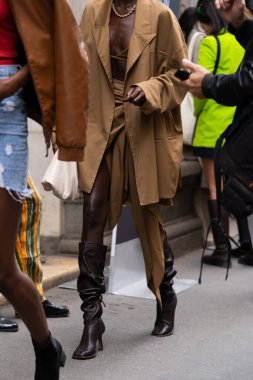 Milan, İtalya - 21 Eylül 2022: Deve kahverengi ceket giyen şık kadınlar, etek ve hasat bluzu, kahverengi topuklu ayakkabılar, bej deri çanta, sokak tarzı kıyafet ayrıntıları