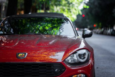 Milan, İtalya - 1 Eylül 2022. Kırmızı Abarth 124 Spider 'ın ön tarafı kasabanın caddesinde park halinde.